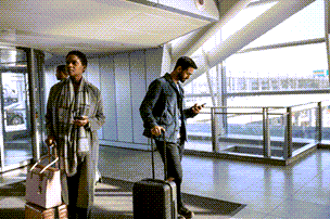 Lidé na letišti kontrolující svá bezdrátová zařízení.