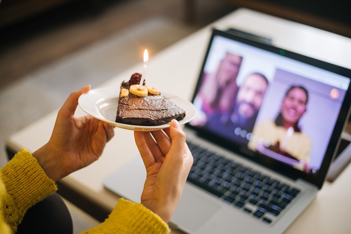 billede af en person, der holder et billede af kage foran et webkamera