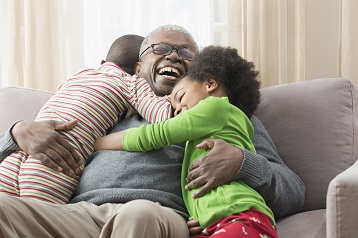 Et billede af to børn, der giver deres bedsteforælder et knus