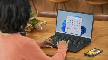 Frau, die an einem Laptop arbeitet, der Windows 11