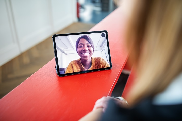Foto einer Person, die ein Tablet mit Videokonferenz verwendet