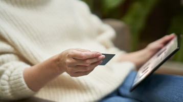 Frau, die eine Kreditkarte und einen Laptop hält