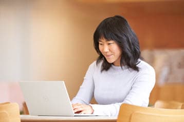 A photo of a woman using a laptop.