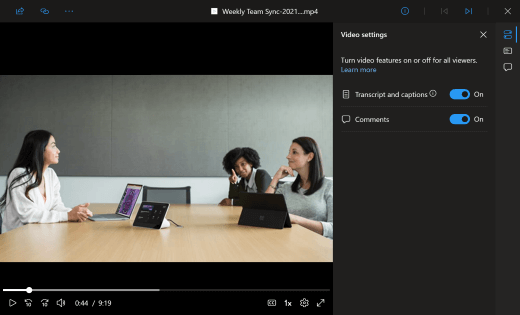 An in-browser video player shows a Teams meeting in progress. Three office workers sit around a conference table with devices in front of them. Text in the right-side video settings panel shows Admin users where they can toggle on or off the transcript and captions and comments features for all users.