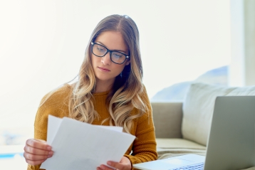 A woman in glasses reviewing paperwork