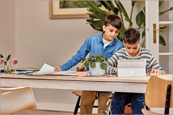 Dos estudiantes jóvenes mirando un dispositivo Microsoft Surface