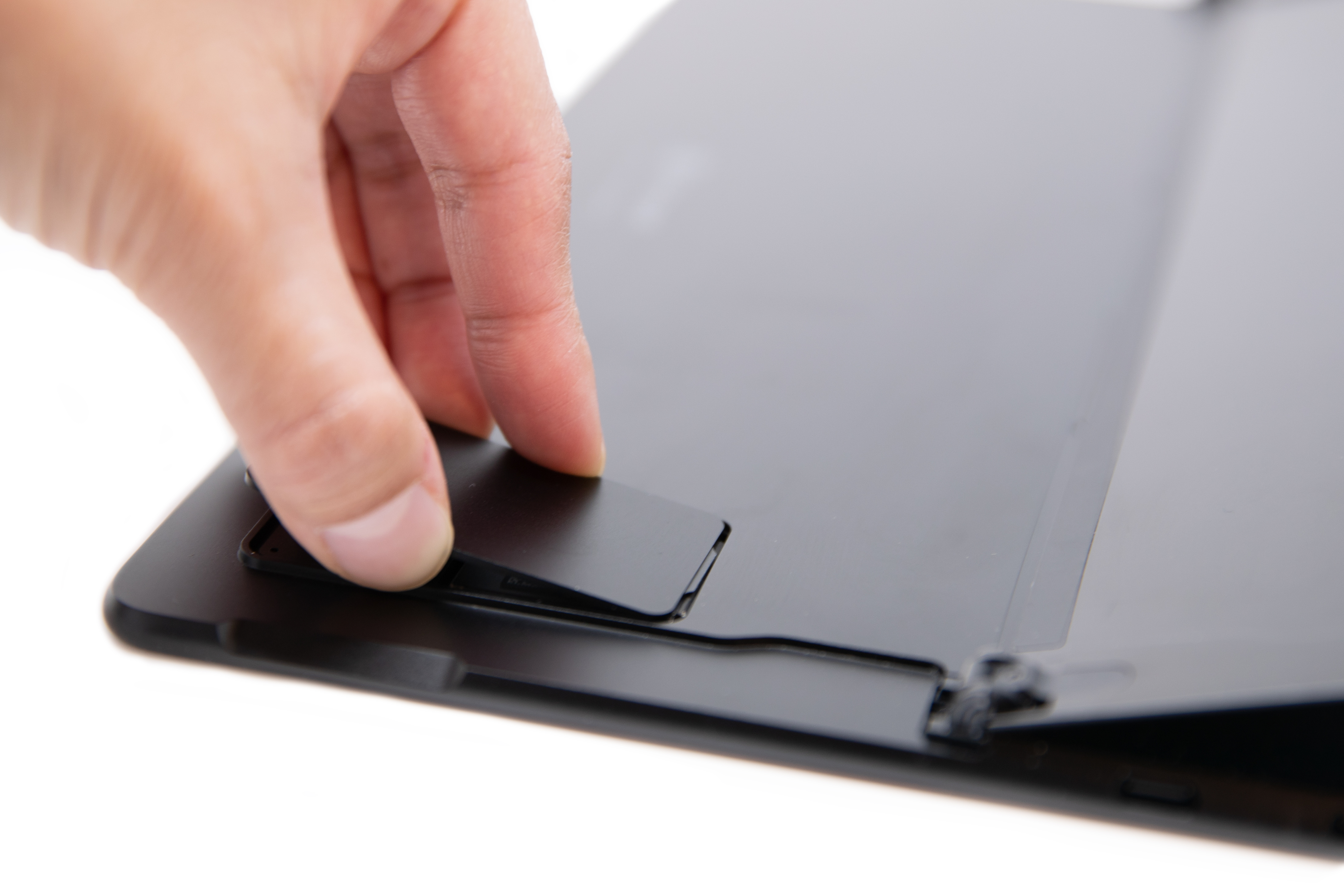 Inimene lükkab Surface Pro X-i SIM-kaardi luugi algasendisse.