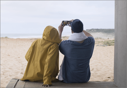 Couple prenant une photo sur la plage