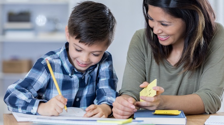 photo d’un adulte aidant un enfant avec des devoirs.