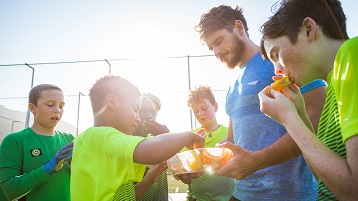 photo d'enfants dans une équipe sportive mangeant des snacks