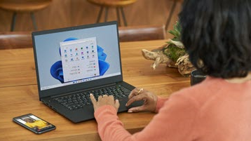 אישה עובדת במחשב נישא שבו פועל Windows 11