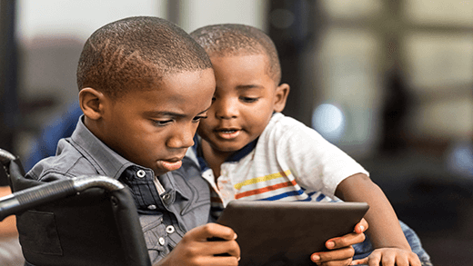 ילד אפרו-אמריקאי משחק ב- Tablet עם אחיו הצעיר