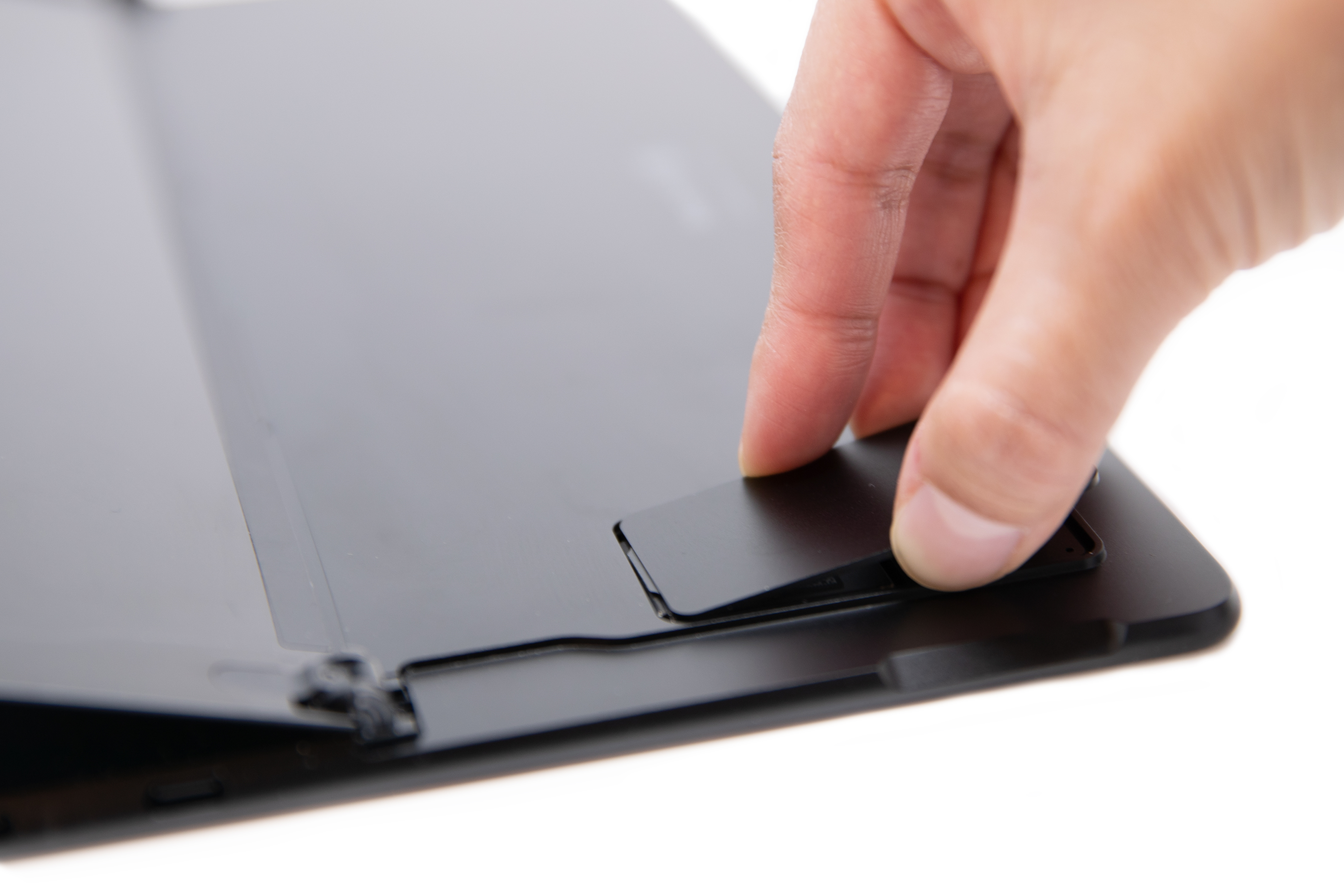 אדם מ להחליק את דלת ה- SIM של Surface Pro X למיקום המקורי.
