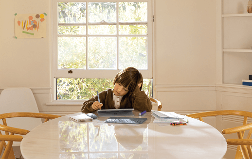 ילד משתמש במחשב tablet ליד שולחן.
