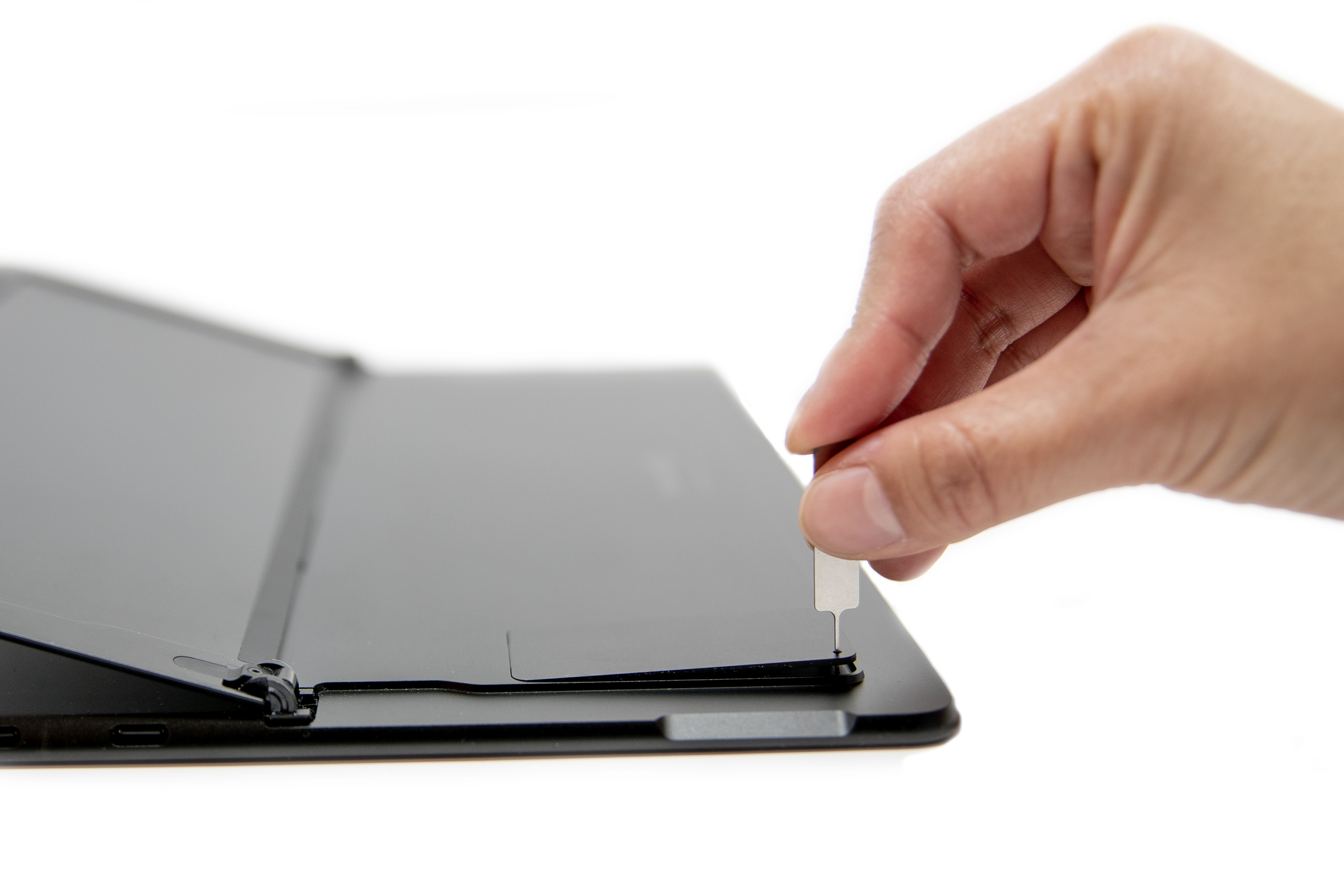 יד של אדם הוכנסה מפלט SIM Surface Pro X.