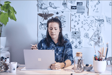 Foto seorang wanita bekerja menggunakan komputer laptop.