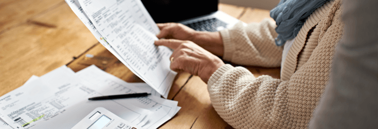 Donna anziana che riceve assistenza con documenti finanziari da un'altra persona