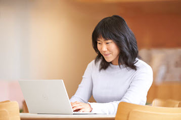 Moters, naudojančios nešiojamąjį kompiuterį, nuotrauka.
