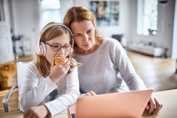 En mor og datter som ser på en datamaskin