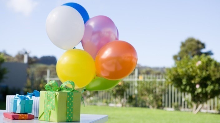 foto van een verpakt cadeau en ballonnen