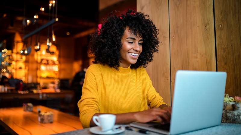 Foto van een vrouw in een café op haar laptop