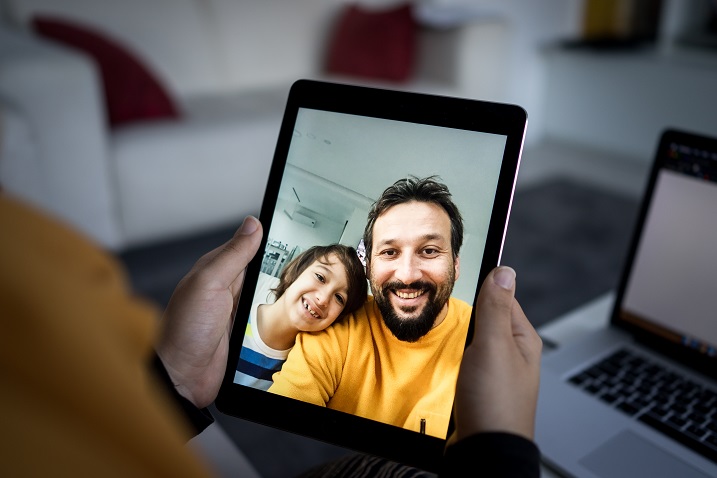 zdjęcie osoby trzymającej urządzenie typu tablet z włączonym połączeniem wideo