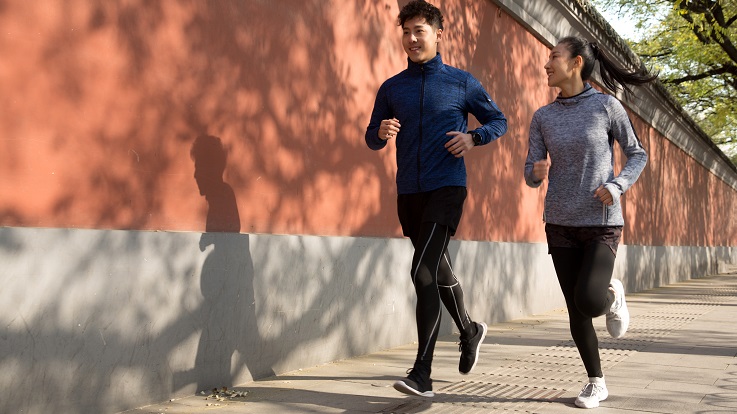 zdjęcie przedstawiające dwie osoby, które uprawiają jogging poza domem
