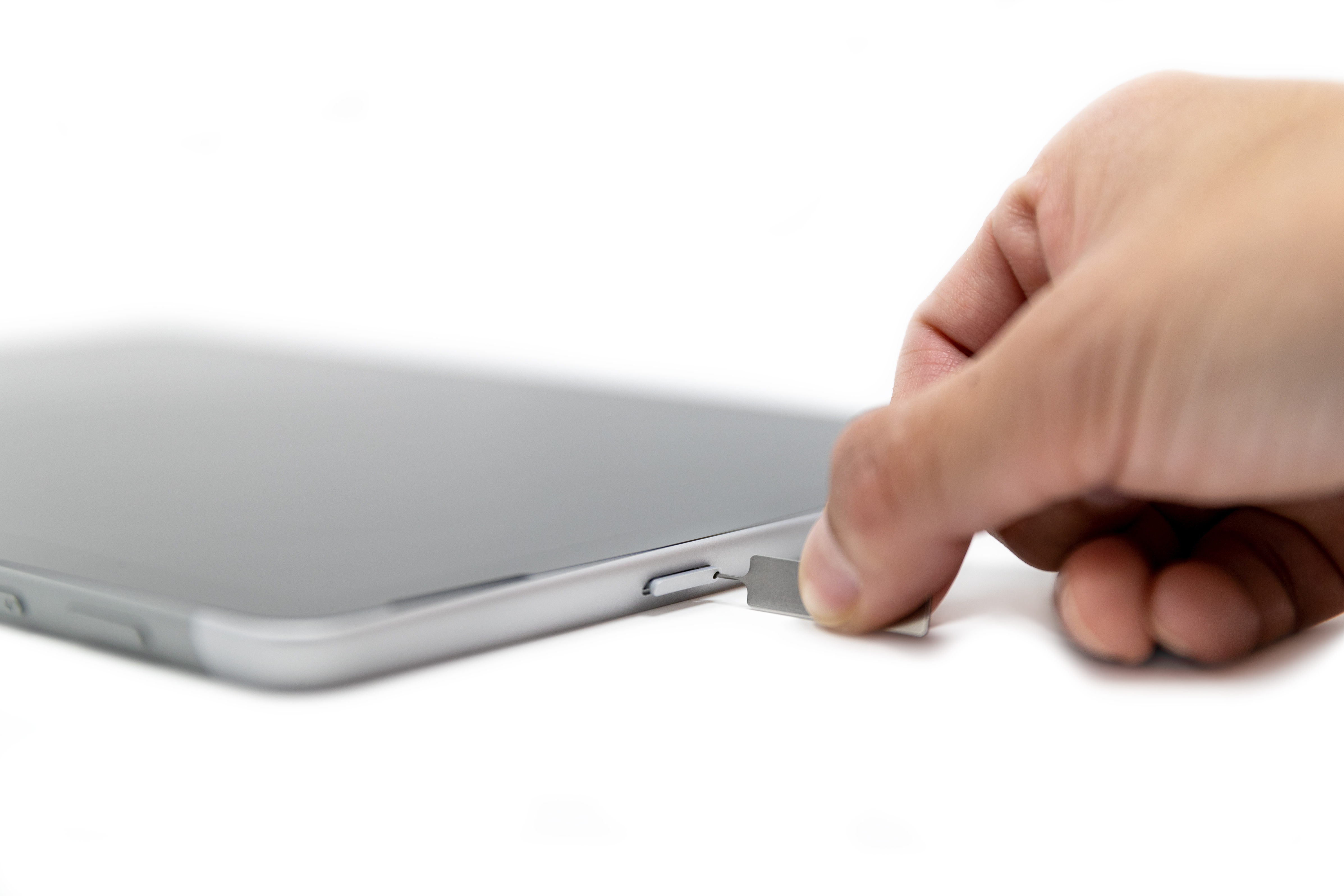 Uma pessoa inserindo um pino SIM no slot sim cartão de um Surface Go 2.
