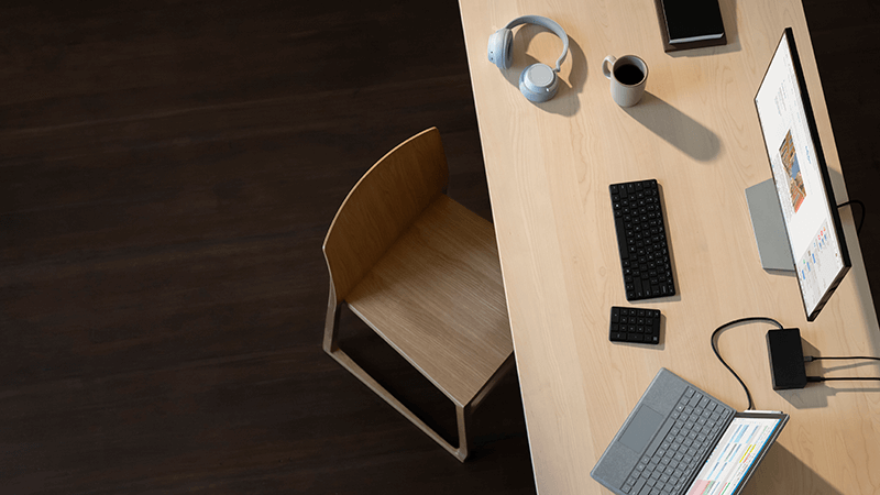 Surface Pro, Surface Headphones, mouse e teclado em uma mesa