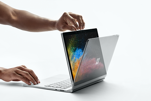 Imagem de uma mão abrindo um Surface Book 2 enquanto estiver no modo Modo de Exibição.