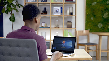 Um homem trabalhando em um laptop com Windows 10