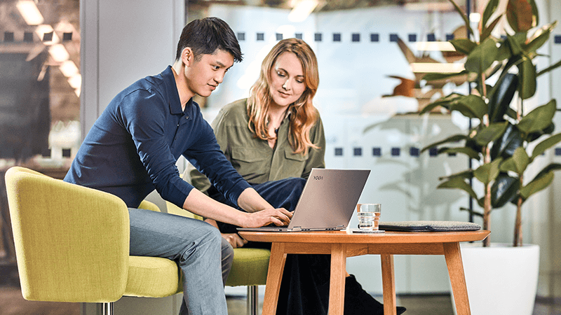 Homem e mulher observando juntos em um laptop.