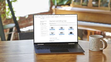 Laptop on a table beside coffee mug open to Payment and billing help topics page